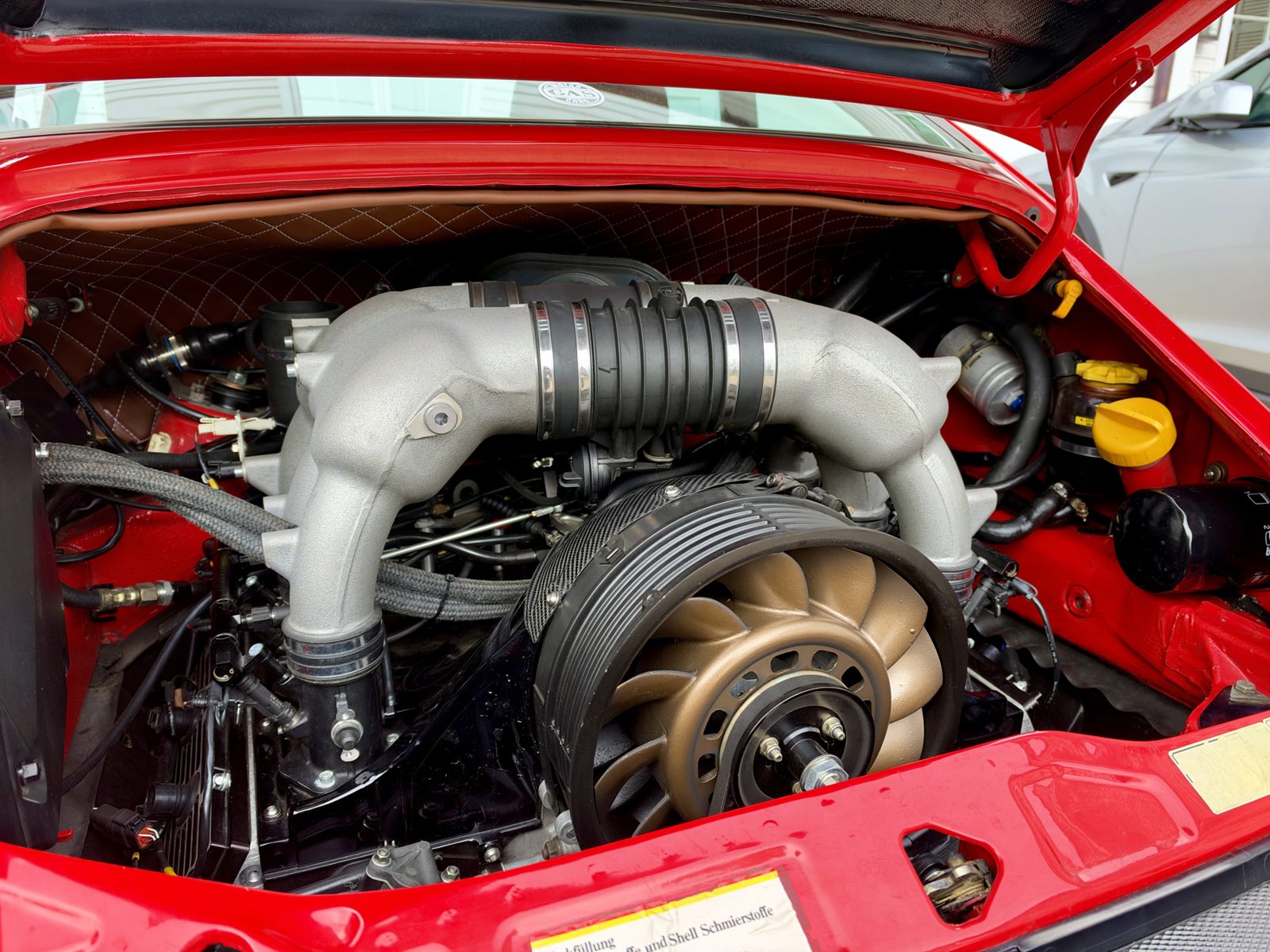 Engine bay: GT3-pattern twin plenums with center resonance tube over individual throttle bodies