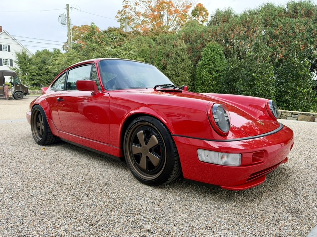 Guards Red 964 Carrera 2, front three-quarter, on gravel with bronze Rotiform wheels