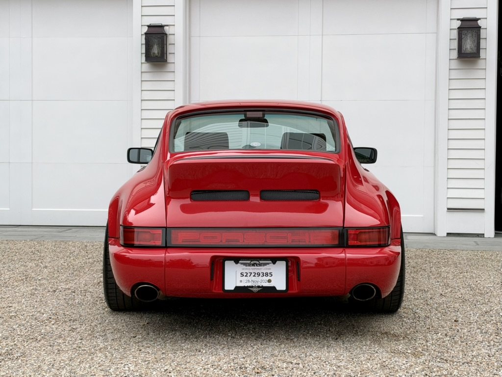 Rear view: ducktail with vents, black centre reflector with PORSCHE script, dual oval exhaust tips
