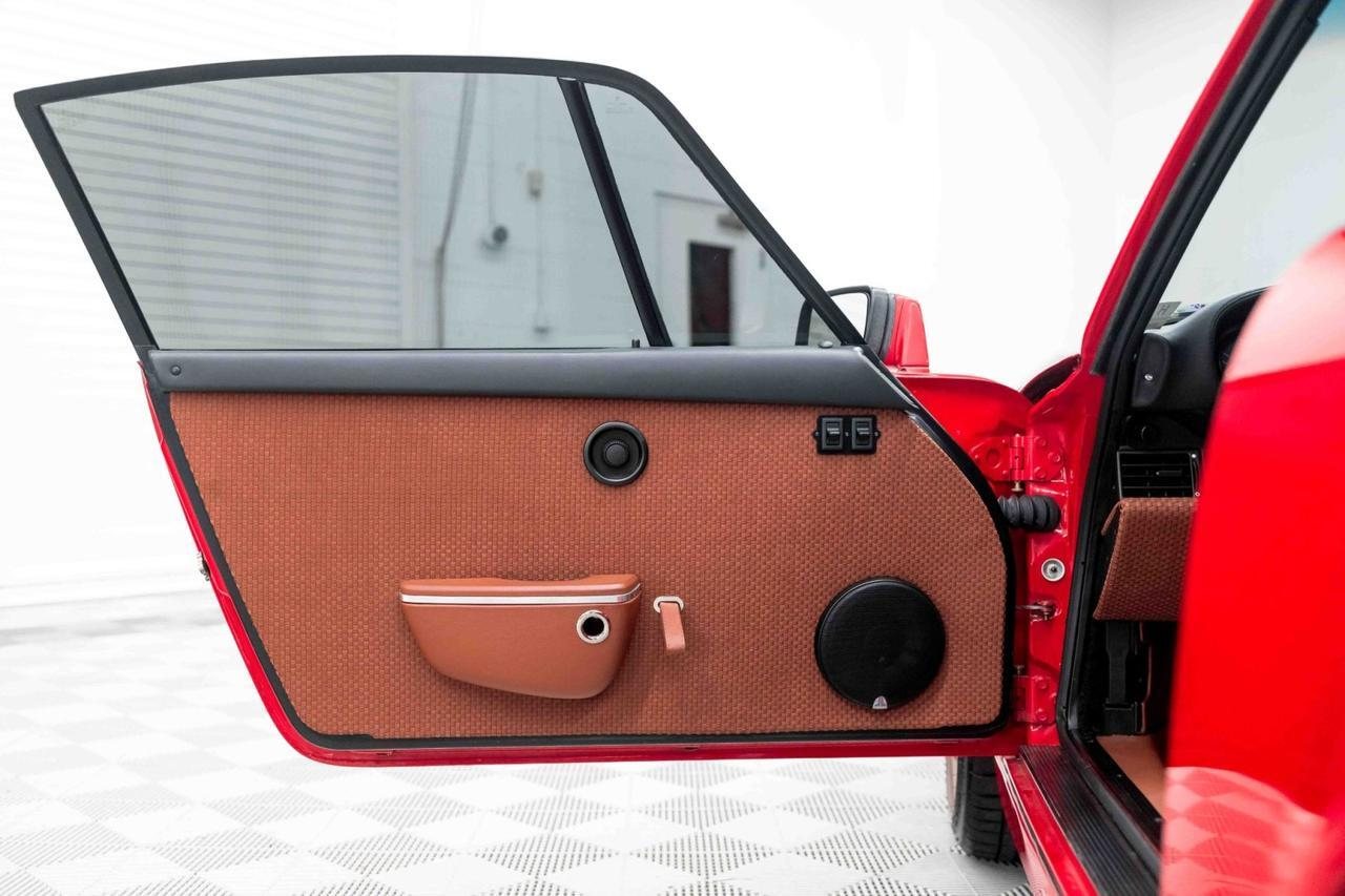 Door card in Bourbon leather weave with smooth leather door pocket, fabric pull strap and speaker