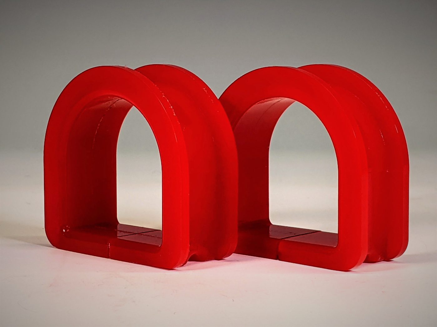 Two red polyurethane steering rack bushings